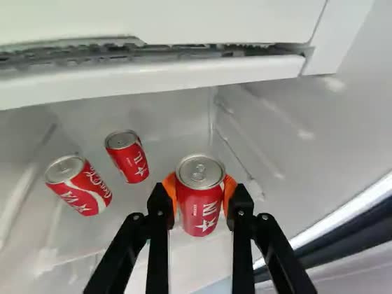 Wrist camera: inside a refrigerator, the gripper closes around one of three red drink cans on a white shelf.